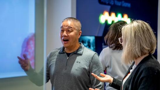 Guests talking and gesturing enthusiastically at the Chicago BIC, with digital signage near them.