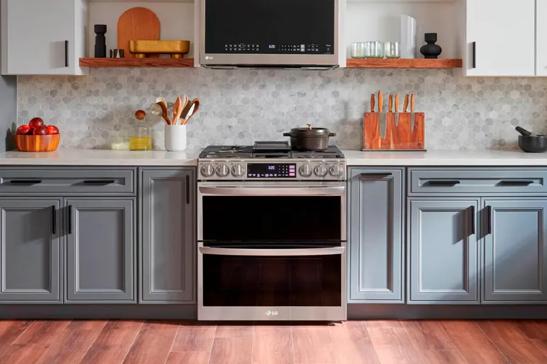 Modern kitchen with stainless steel oven and blue-gray cabinets.