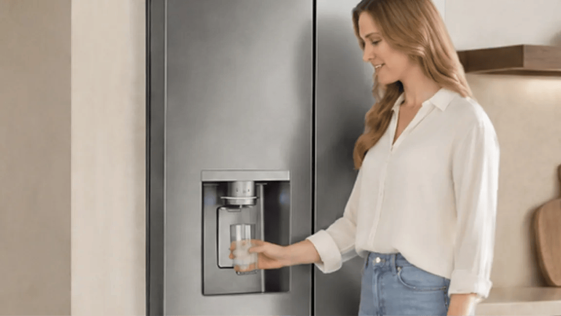 A woman fills her glass from an LG Refrigerator water dispenser. 