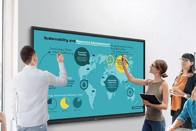 People interacting with a large screen displaying a sustainability infographic.