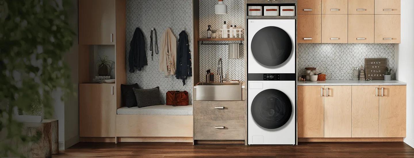 LG built-in stacked washer and dryer in a modern laundry room with wood cabinetry and bench seating.