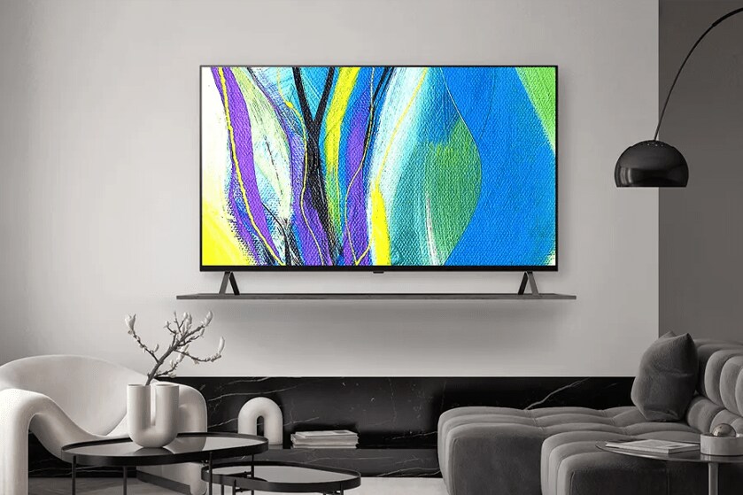 A modern upscale hotel room, with an LG Pro:Centric SMART OLED Hotel TV. The TV displays a bright abstract painting on its screen. 