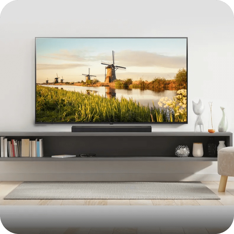 Compact soundbar under wall-mounted TV with a gold-lit backdrop and minimalist decor.