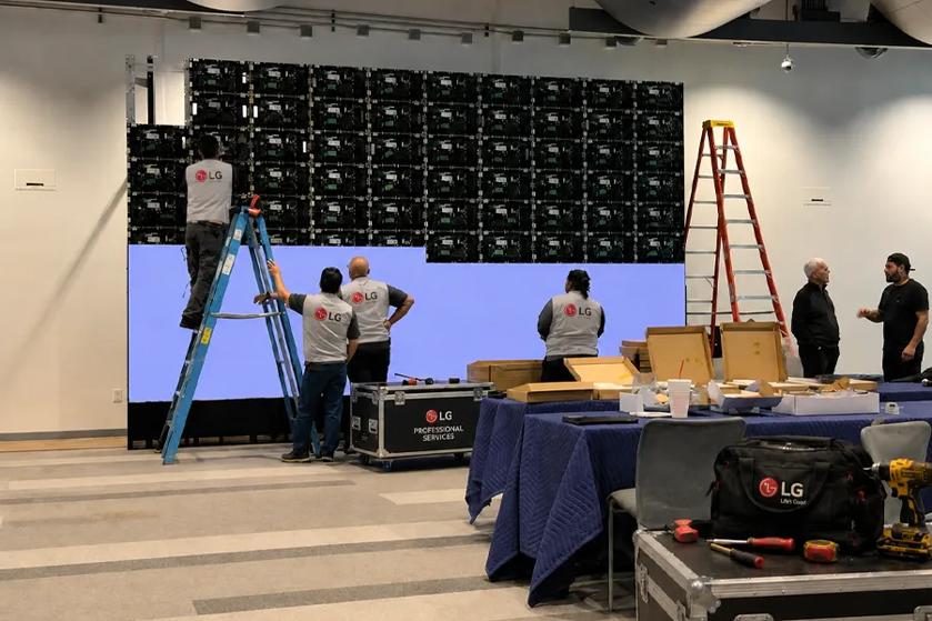 Workers install indoor LG Direct View LED panels