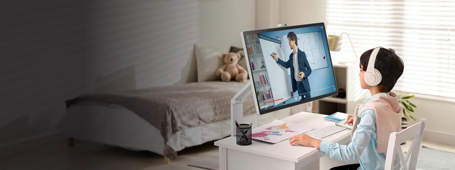 A young child in their bedroom watches a lecture on an LG Smart Monitor Swing while taking notes .