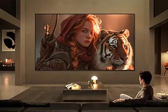 LG TV for watching movies fills a modern living room with a cinematic scene on a large wall-mounted display, featuring a detailed close-up of a character and tiger, highlighting rich color depth, strong contrast, and immersive viewing.