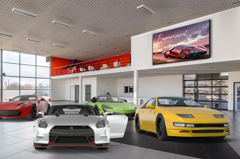 Showroom with red, silver, green, and yellow sports cars and a digital sign reading "Empowerment."