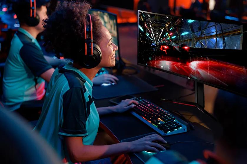 A university student grins as she plays an esports video game on an LG Gaming Monitor.