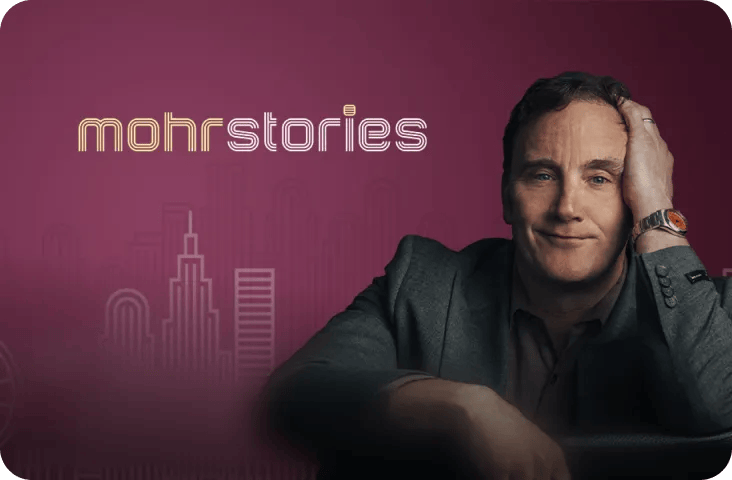 Promotional graphic for the 'Mohr Stories' podcast, featuring a headshot of Jay Mohr leaning on his hand against a purple background with a stylized text logo and a minimal city skyline outline.