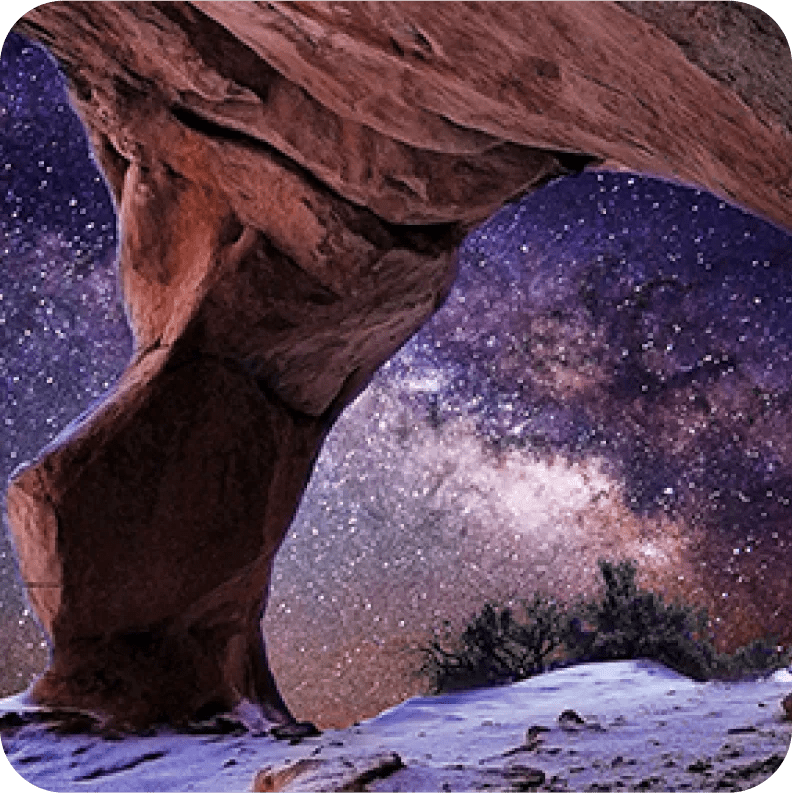 A view of a starry sky through a rocky cave opening, showcasing vibrant colors and sharp 4K detail.