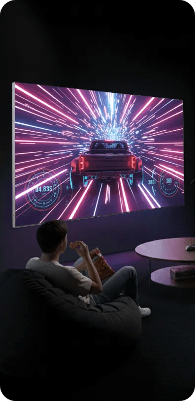 LG Ultra-Large TV in a dark, modern room displaying a high-speed, neon-lit sci-fi racing scene.