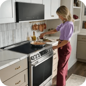 A woman cooks a meal on an LG range.