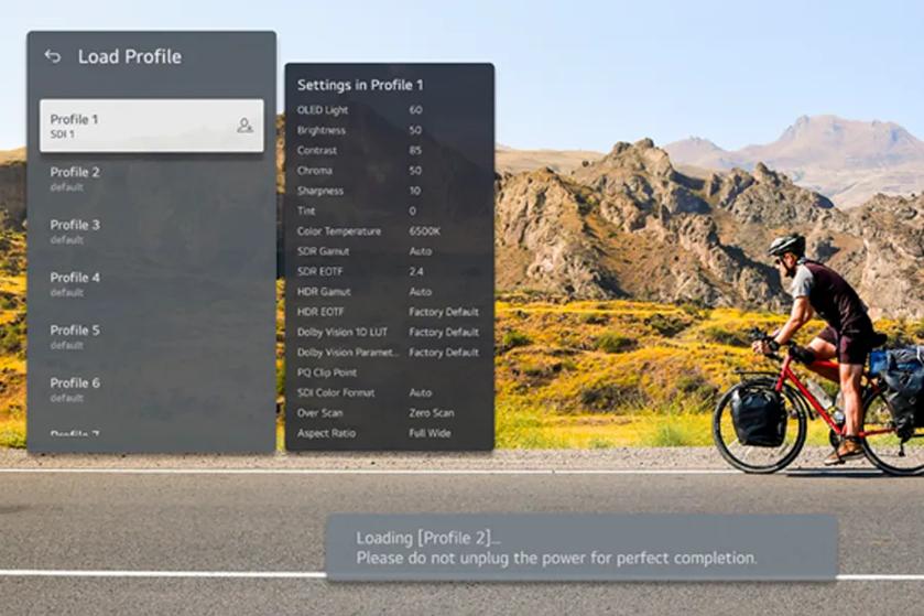 A cyclist rides along a mountain road with digital settings menus overlaid on the image.