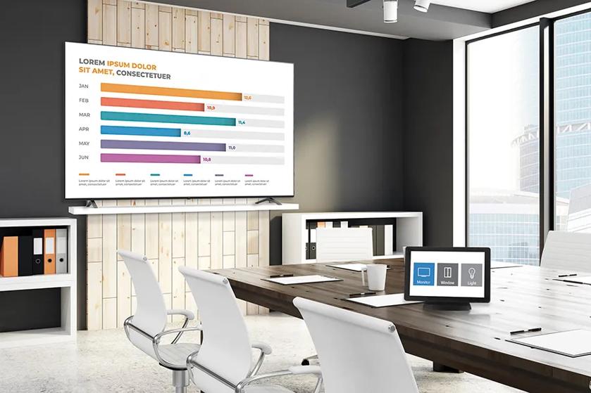 Modern meeting room with a large screen displaying a bar chart and a conference table with chairs.