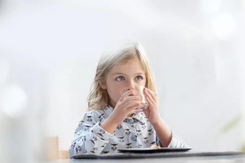Young girl drinking a glass of water