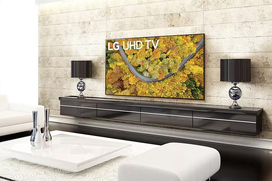 A luxury living room with a TV displaying an aerial view of woods in red.