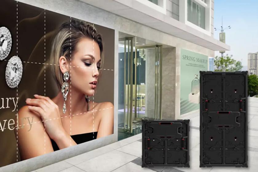 Modern building exterior with large ad showing a woman, display panels in front, and a "SPRING MAKEUP" sign in the background.