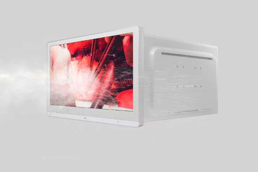 A cloud of dust blowing against a white medical monitor displaying a surgical procedure.