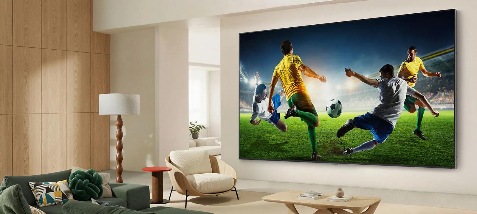 LG TV featuring AI Super Upscaling is displayed on the wall in a contemporary living room, showcasing a dynamic soccer match upscaled to vivid 4K resolution with enhanced color and detail for immersive viewing.