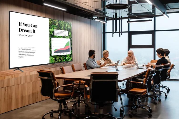 Professionals in a conference room with LG digital signage displaying a presentation
