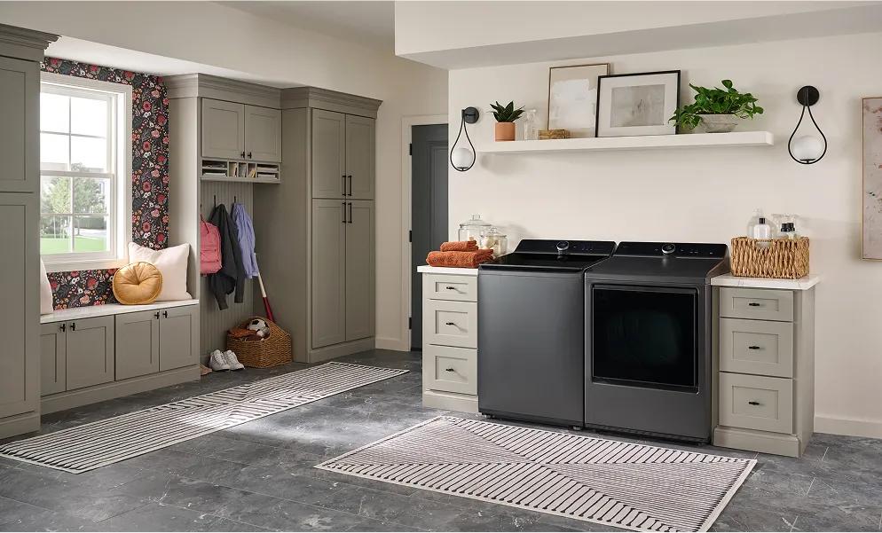 Dark gray top-load washer and front-dryer in a modern laundry room.