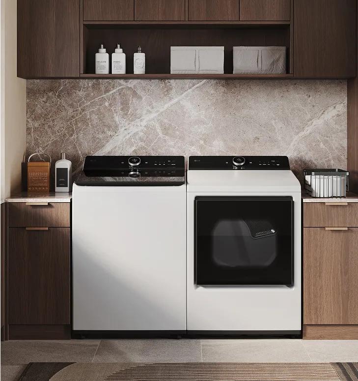 White top-load washer and white front-load dryer in a modern laundry room with brown cabinets around it.
