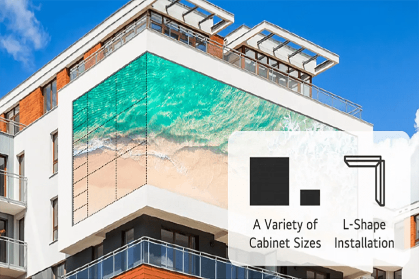 A building with an L-shaped digital display showing a beach scene.