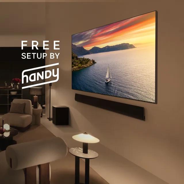 A modern living room featuring an LG OLED TV mounted on the wall above a comfortable couch, showcasing a Free setup by Handy.