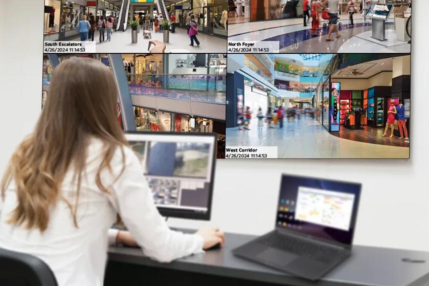 A security guard sits in the back office, using the LG tiled video wall, LG monitor, and gram laptop to watch over the shopping mall. 
