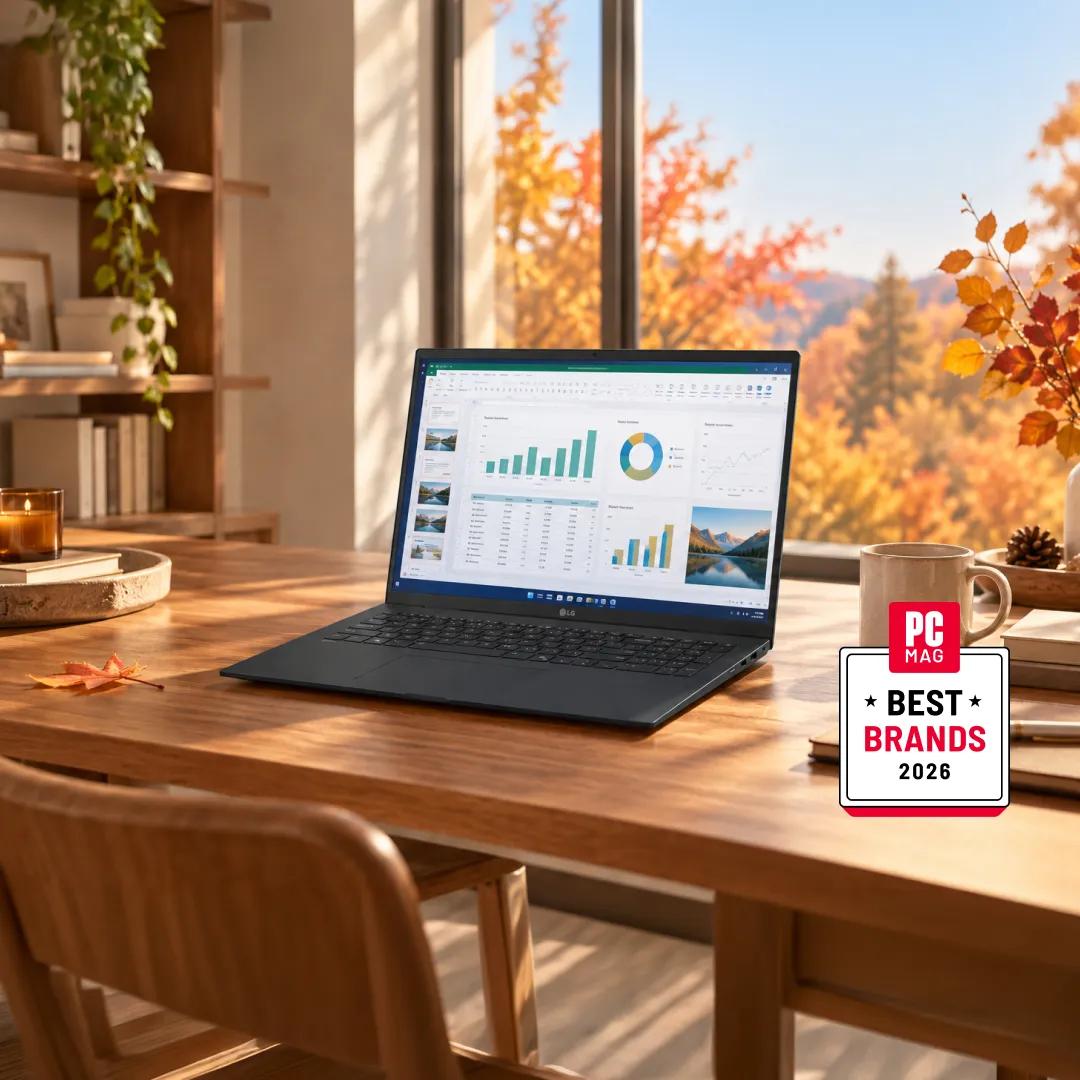 An LG laptop on a wooden table showing charts and a spreadsheet, beside a window with autumn foliage, with a PCMag Best Brands 2026 badge.”