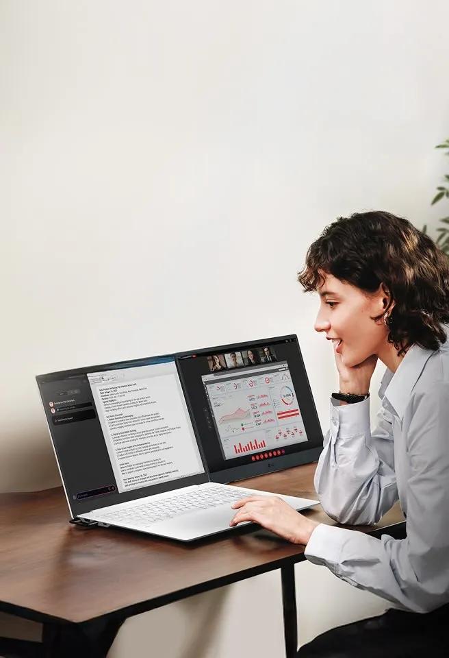 A woman uses an LG gram laptop with a dual screen setup for video conferencing and multitasking in her home office.