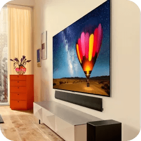 An LG OLED TV is mounted on the wall above an LG soundbar and showcases an image of a colorful hot air balloon.