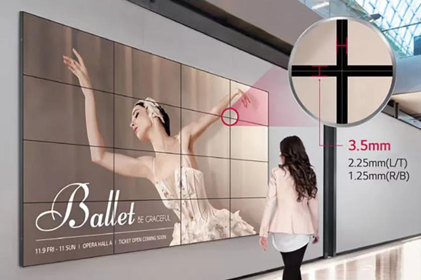 Video wall displaying ballet advertisement with a woman walking by and inset measuring seam thickness.