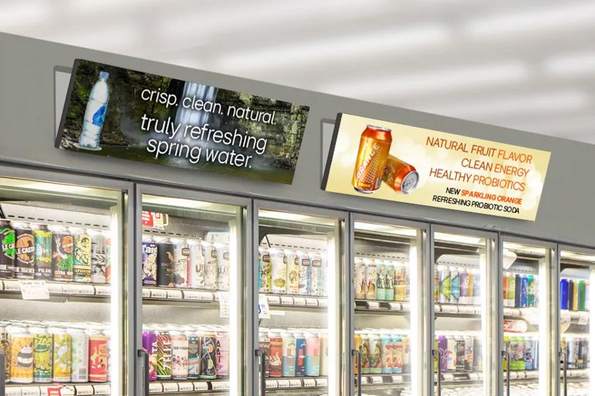 LG stretch signage advertises drinks above beverage coolers in a grocery store.