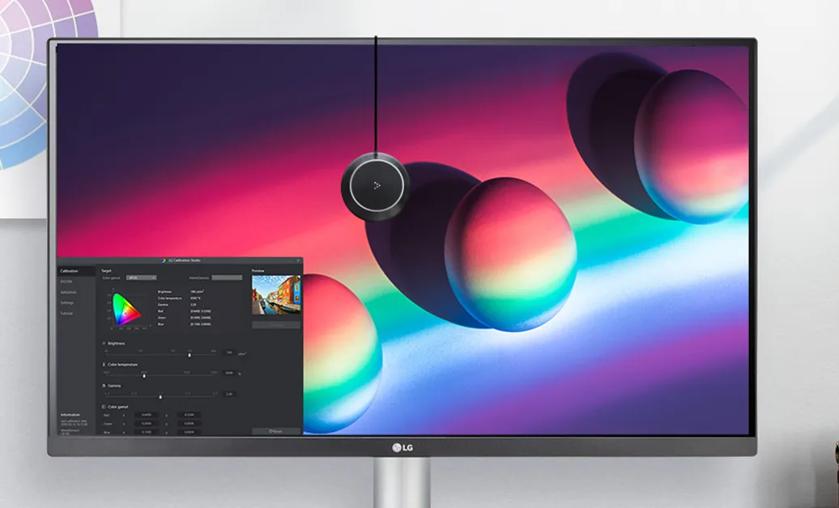 A computer monitor displaying colorful graphics with a calibration tool in front.