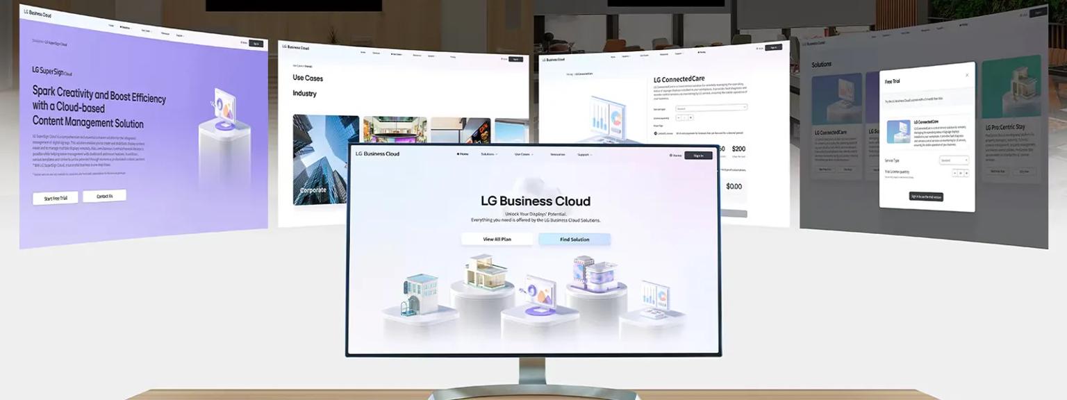 Digital monitors displaying LG Business Cloud webpages in a modern office setting.