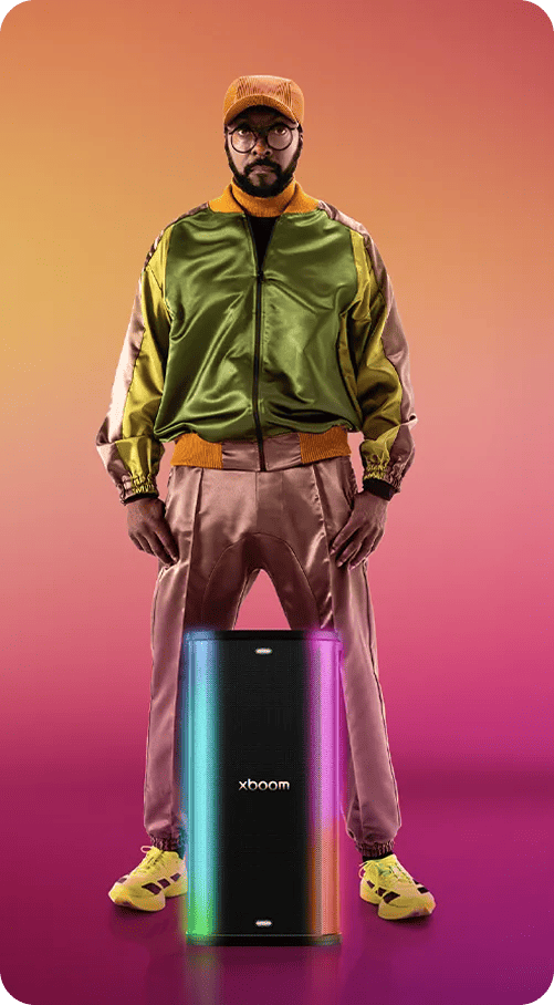 Will.i.am carrying an xboom speaker with both hands