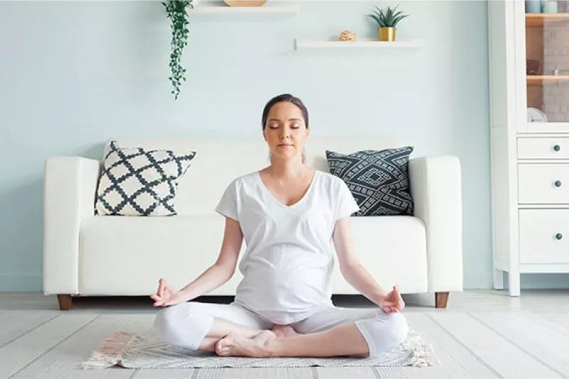 a woman does a meditation in her living room