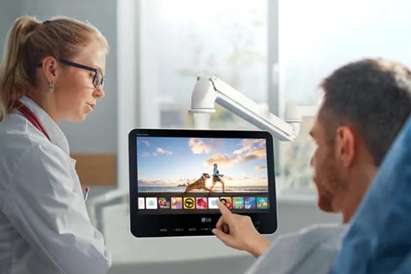 Patient using LG Hospitality TV touch screen.