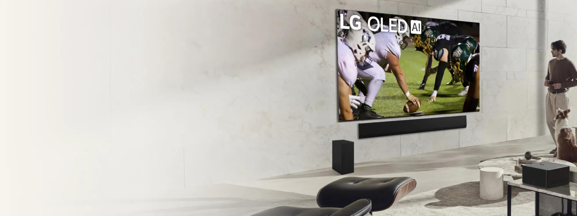 A person and a dog watching football on LG OLED TV with AI mounted on a wall with Sound bar system.