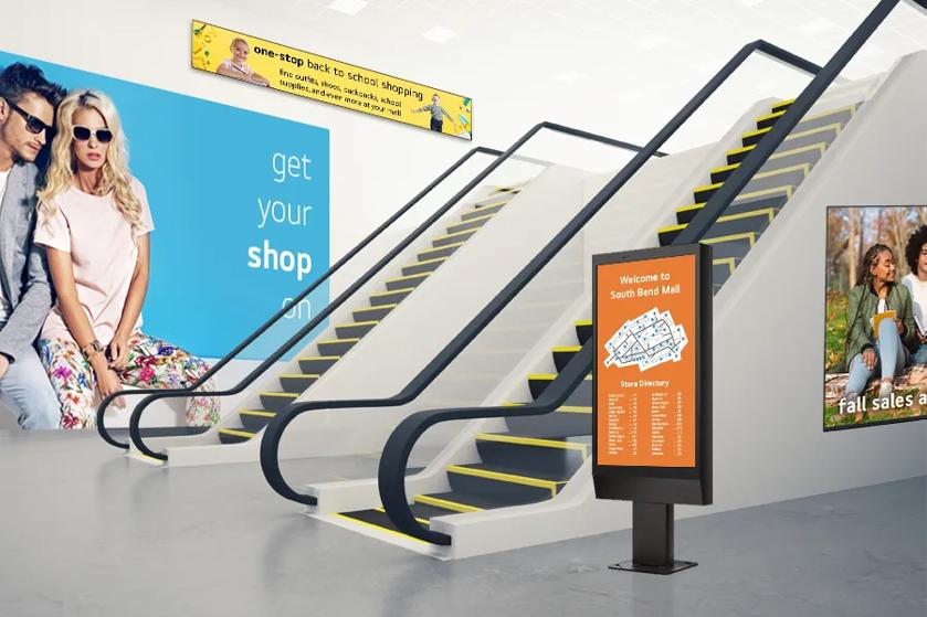 LG signage featuring advertisements and a map near a shopping mall's elevator.