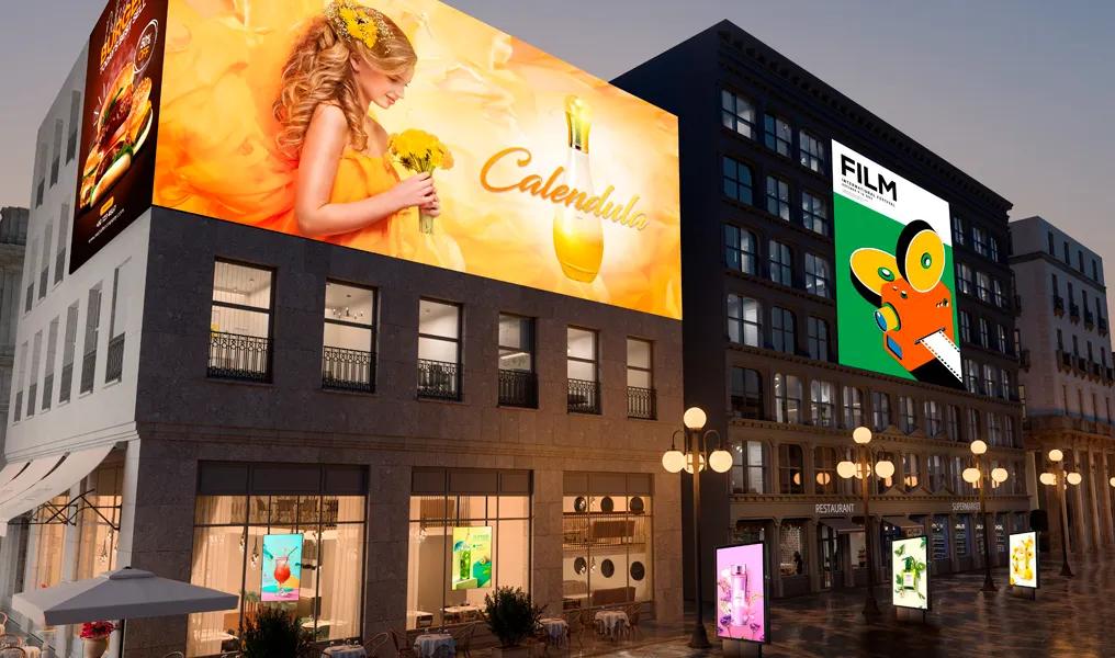 A city street at dusk with buildings displaying large, colorful billboards; one with a woman in orange, another with abstract art and the word "FILM."