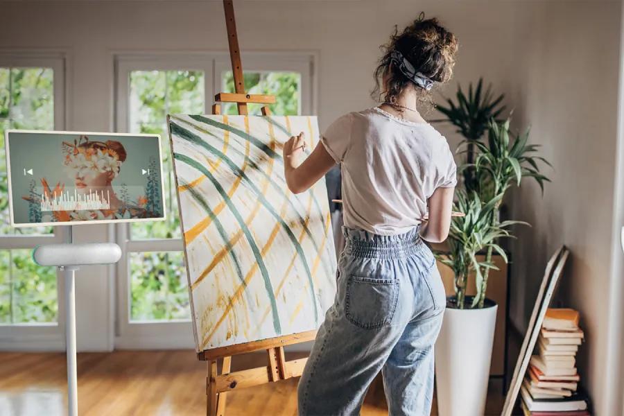 Image of a woman painting next to the XT7S stanbyME speaker and StanbyME display