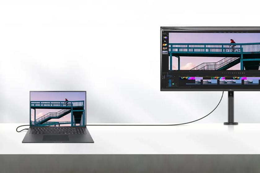 gram Laptop and lg ergo monitor displaying the same image of a cyclist on a bridge, connected by a cable.