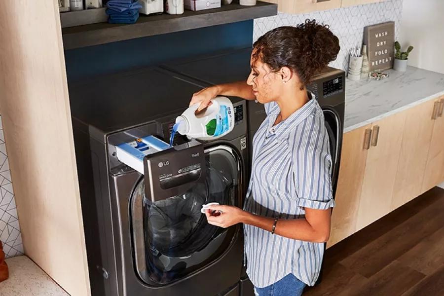 A woman pouring detergent in the LG washer