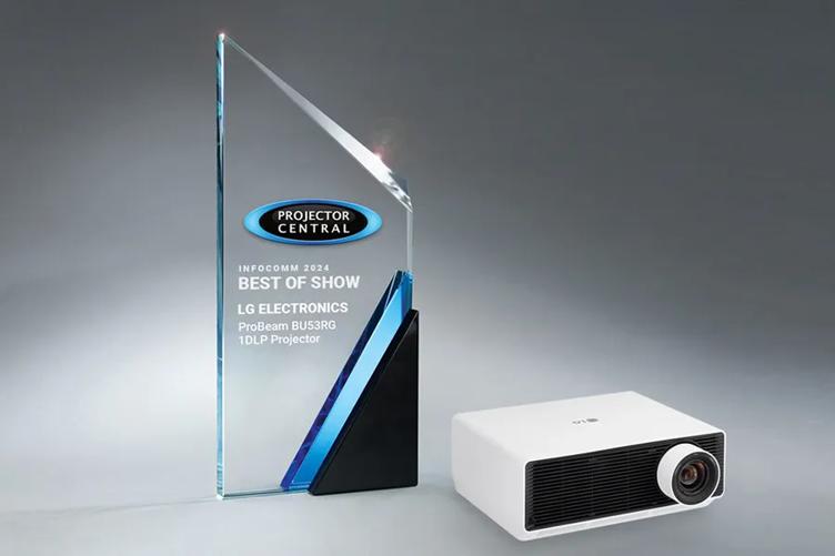 An LG ProBeam Projector sits on a smooth grey background. Next to it is a glass award with words reading: Projector Central, Infocomm 2024, Best of Show, LG Electronics, ProBeam BU53RG 1DLP Projector.