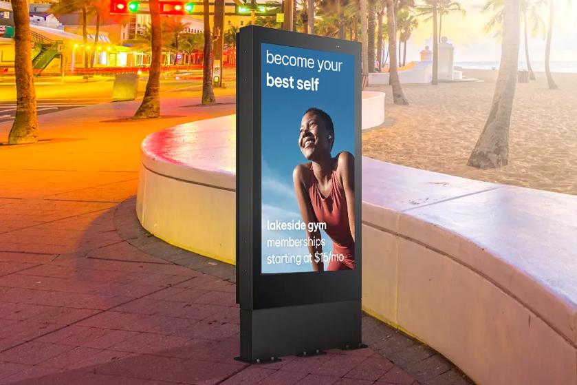 75XE3C outdoor signage in the sun with fitness ad displayed on it. The graphics are bold and visible despite the bright sunlight.