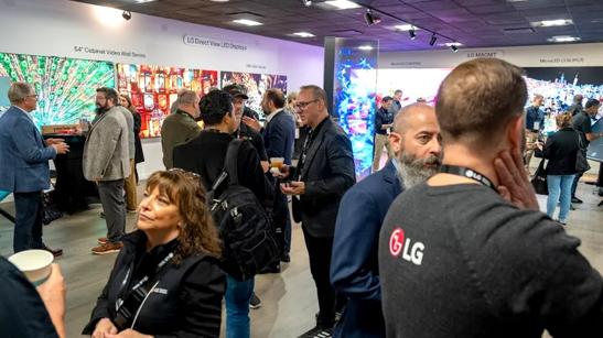 A crowd of business people, some wearing shirts with the LG logo, mingle and talk in the Chicago Business Innovation Center. 