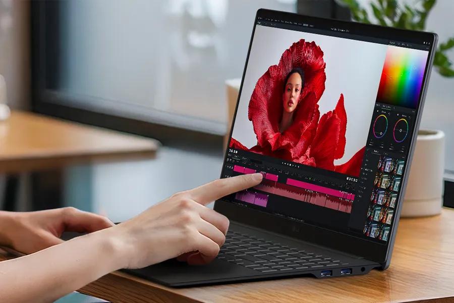 LG Gram 17Z90U-H touchscreen laptop showing photo editing software with finger touching display for intuitive control