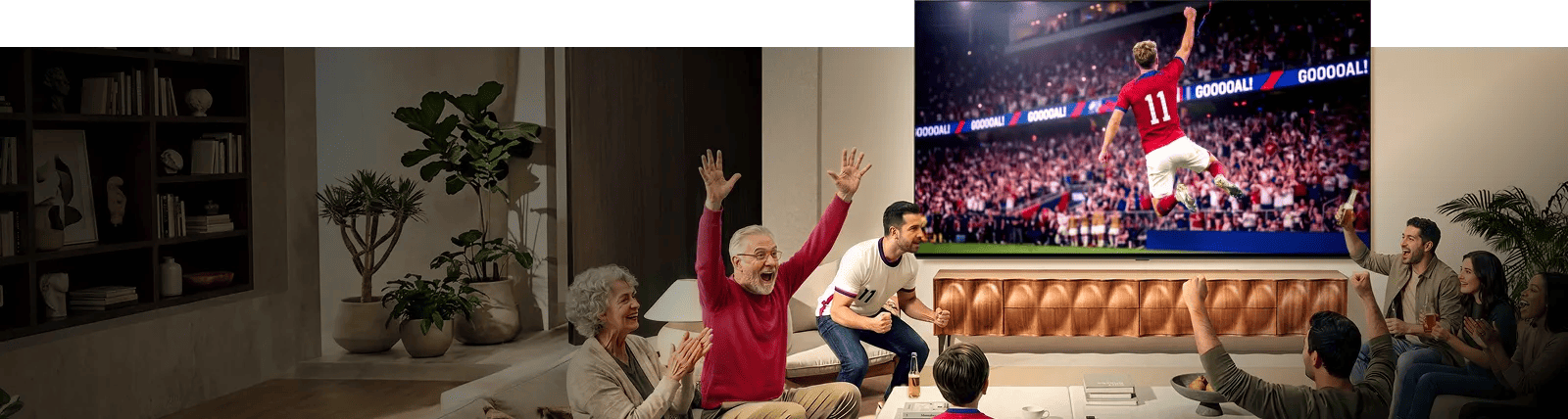 Family on couch cheering as soccer match plays on LG Big Screen TV that's showing a player leaping into the air, one arm raised, before a massive stadium crowd.
